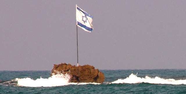 Isrlische vlag op rotspunt in de branding bij Jaffa / Tel Aviv